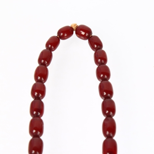 1231 - A single-strand graduated cherry amber barrel bead necklace, beads ranging from 34.4-12mm, necklace ... 