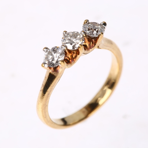 1250 - A modern 9ct gold three stone diamond ring, claw set with modern round brilliant-cut diamonds, total... 