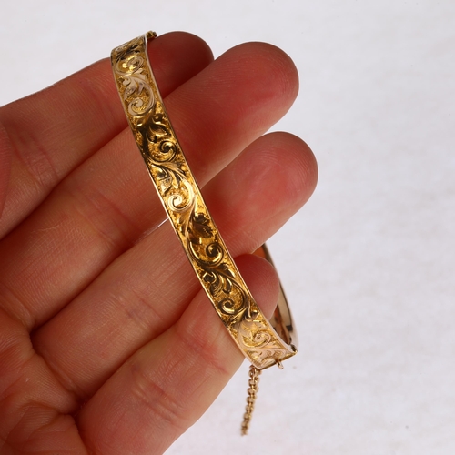 1254 - An early 20th century 15ct? rose gold hinged bangle, chased foliate decoration, band width 6.7mm, in... 