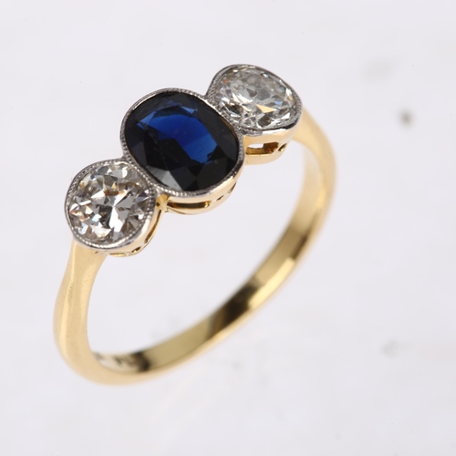 1261 - An 18ct gold three stone sapphire and diamond ring, platinum-topped, rub-over set with 0.8ct oval mi... 