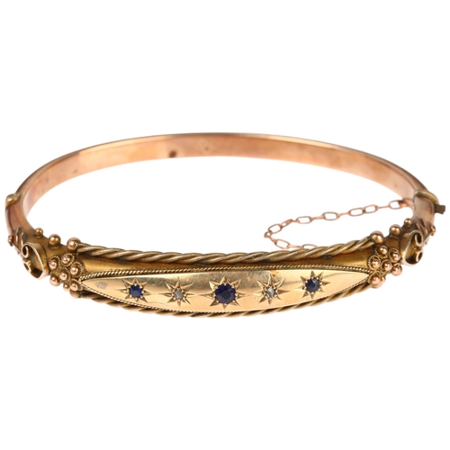 1262 - A Victorian 9ct rose gold sapphire and diamond hinged bangle, with applied rope twist and floral dec... 