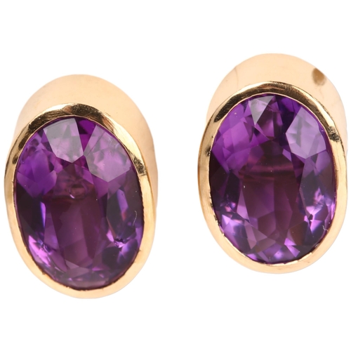 1293 - A pair of solitaire amethyst earrings, unmarked yellow metal rub-over settings with oval mixed-cut a... 