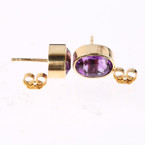 1293 - A pair of solitaire amethyst earrings, unmarked yellow metal rub-over settings with oval mixed-cut a... 