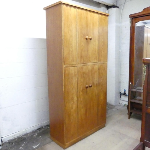 2025 - A mid-century oak record / vinyl cabinet, having four bi-fold doors and fitted interior. 102x203x46c... 