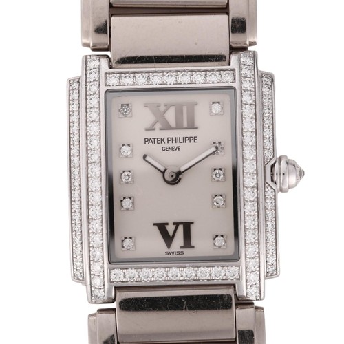 PATEK PHILIPPE - a lady's 18ct white gold diamond Twenty-4 quartz bracelet watch, ref. 4908/200G-011, circa 2007, rectangular silvered dial with diamond and Roman numeral hour markers, luminous hands, diamond set stepped bezel, reverse set diamond crown, and 18ct bracelet, total diamond content approx 0.76ct, 6 jewel movement with calibre E15, serial no. 4291155, case width 22mm, working order, 106.3g gross, boxed with papers
