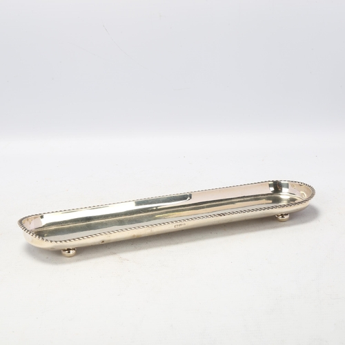 1709 - An Edwardian silver pen tray, indistinct maker, Chester 1904, gadrooned rim with bun feet, 24.5cm, 3... 