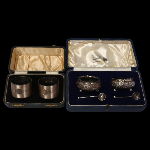 1723 - A cased pair of silver napkin rings, and a cased pair of silver salt cellars, 3.3oz total