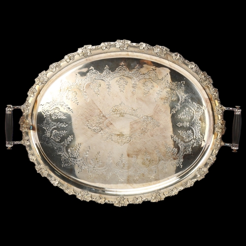 1745 - A large Victorian silver plated 2-handled tea tray, with ebonised handles and grapevine rim, 65cm