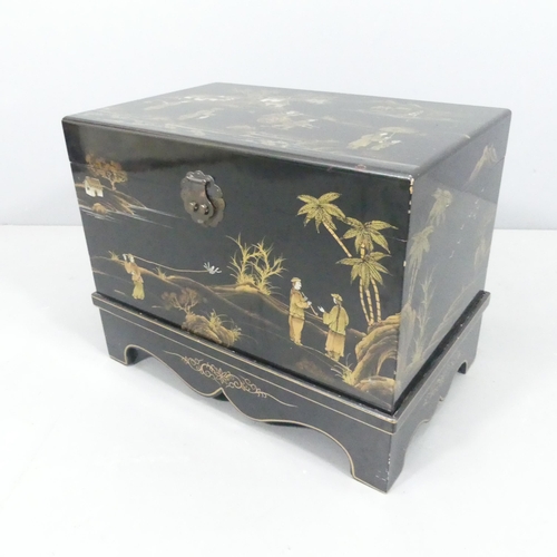 2035 - A modern Chinese black lacquered box on stand, with gilded Chinoiserie decoration. 58x44x38cm