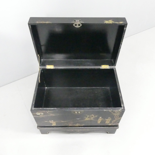 2035 - A modern Chinese black lacquered box on stand, with gilded Chinoiserie decoration. 58x44x38cm