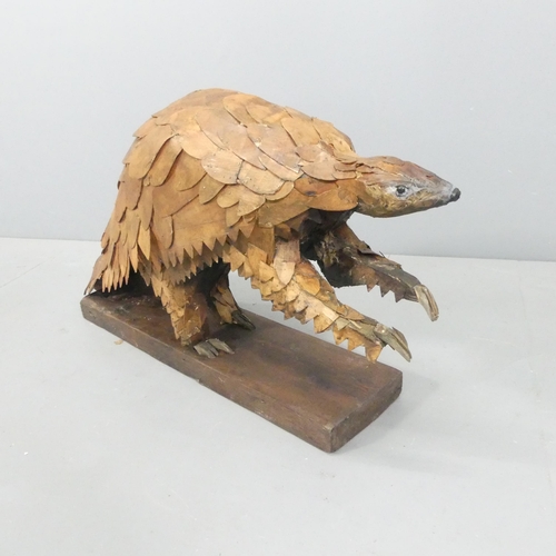 2054 - CLIVE FREDRIKSSON - A hand carved sculpture, study of a pangolin. 85x50x25cm.