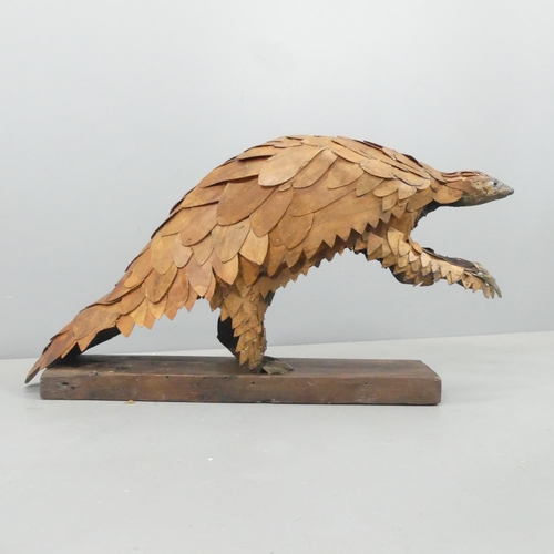 2054 - CLIVE FREDRIKSSON - A hand carved sculpture, study of a pangolin. 85x50x25cm.