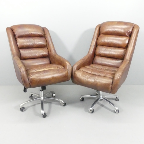 2064 - A pair of mid-century style leather upholstered swivel lounge chairs on chrome star bases, with rise... 