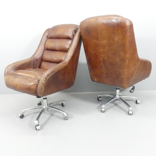 2064 - A pair of mid-century style leather upholstered swivel lounge chairs on chrome star bases, with rise... 