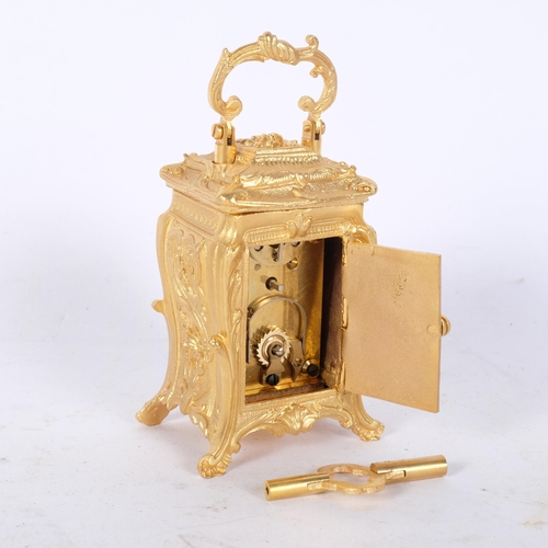 321 - An ornate reproduction miniature gilt-metal carriage clock, with swing handle, height not including ... 