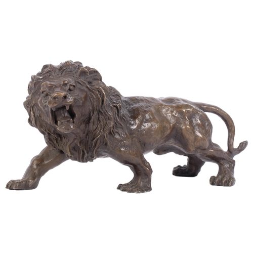 352 - A free-standing bronze sculpture of a roaring lion, H15cm, L32cm