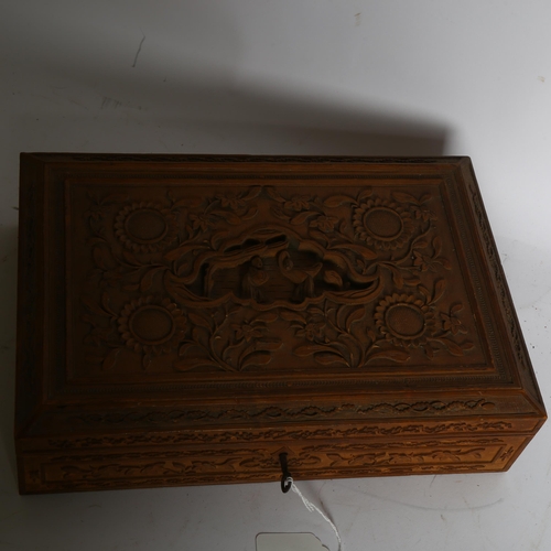 1015 - A Chinese sandalwood carved and engraved box, with relief decorated lid, silk lined, and key, W33cm