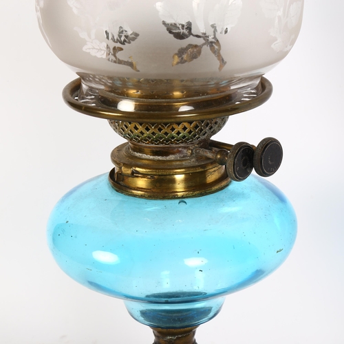 975 - A Victorian oil lamp, with etched frilled shade and blue font, on embossed cast-iron base, overall h... 