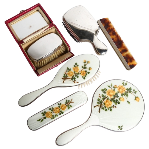 1103 - A white and floral enamelled dressing table brush and mirror set, a boxed silver-backed brush, etc