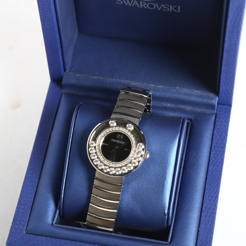 1161 - SWAROVSKI - a lady's quartz wristwatch, with rotating crystals and black dial, no. 1160305, boxed