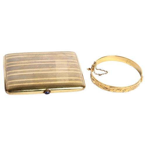 1197 - A gold plated cigarette case with a stone set button, and a gold plated engraved bangle