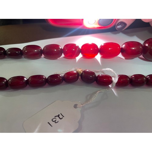 1231 - A single-strand graduated cherry amber barrel bead necklace, beads ranging from 34.4-12mm, necklace ... 