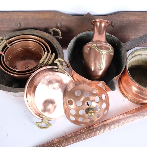 776 - A long-handled copper pan, 77cm, a copper milk pan, and coat hooks, copper pots, colander etc