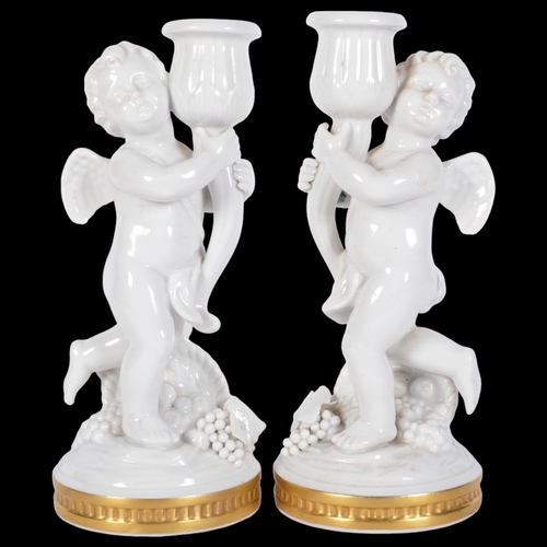 825 - A pair of Vista Alegre cherub candlesticks, signed on base, 21cm