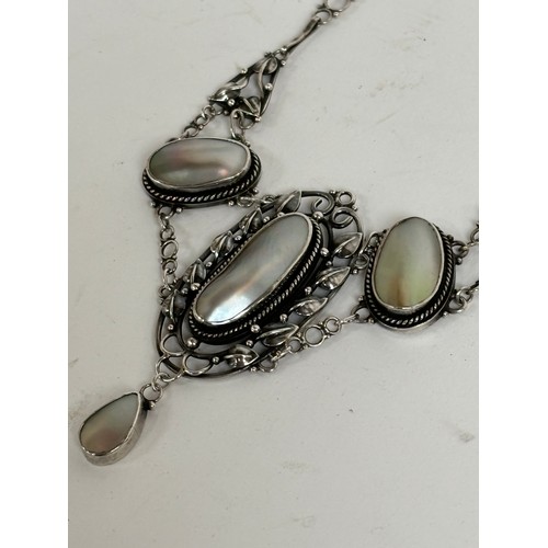 1201 - A stylised unmarked white metal pendant necklace, set with 4 oval pearl panels