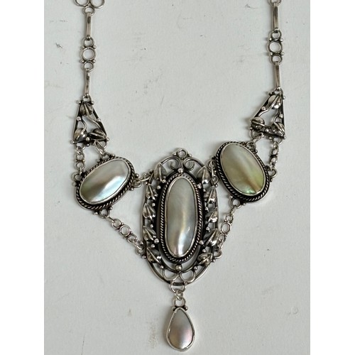 1201 - A stylised unmarked white metal pendant necklace, set with 4 oval pearl panels