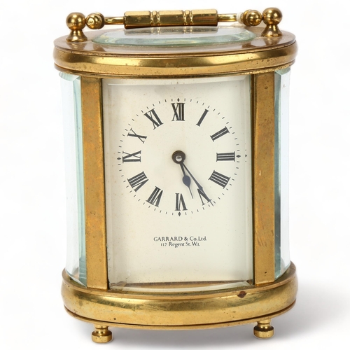 129 - GARRARD - an oval brass-cased carriage clock, case height 11.5cm