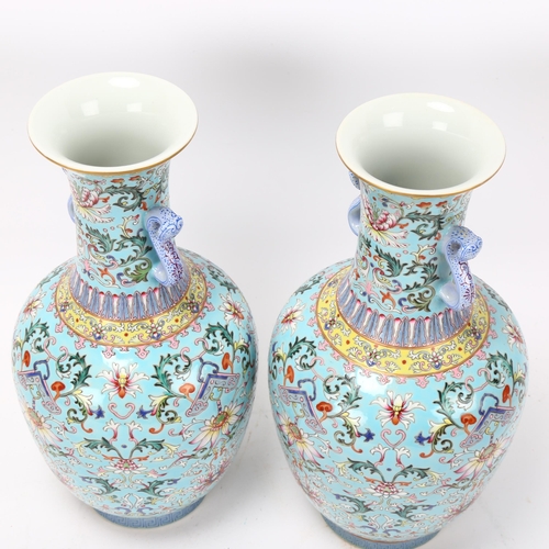 215 - Pair of Chinese pale blue glaze porcelain vases with rui design handles, allover painted enamel flor... 