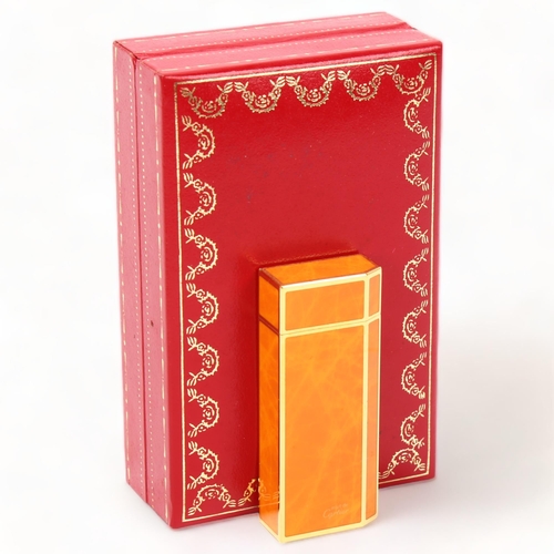 256 - MUST DE CARTIER - Briquet pocket lighter, gilt-metal with orange lacquer, length 6cm, boxed with pap... 