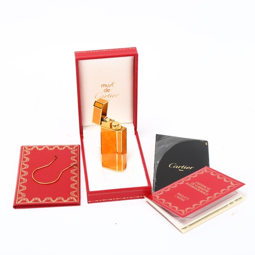 256 - MUST DE CARTIER - Briquet pocket lighter, gilt-metal with orange lacquer, length 6cm, boxed with pap... 