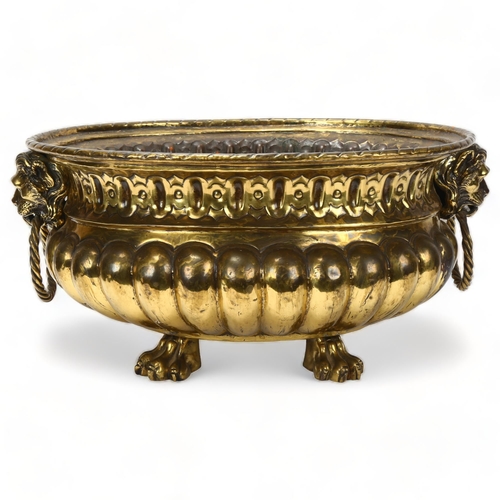 89 - A 19th century oval brass jardiniere, with cast lion mask ring handles and lion paw feet, length 44c... 