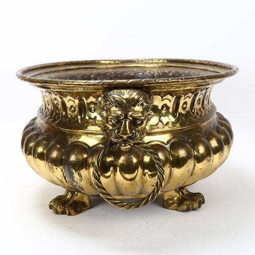 89 - A 19th century oval brass jardiniere, with cast lion mask ring handles and lion paw feet, length 44c... 