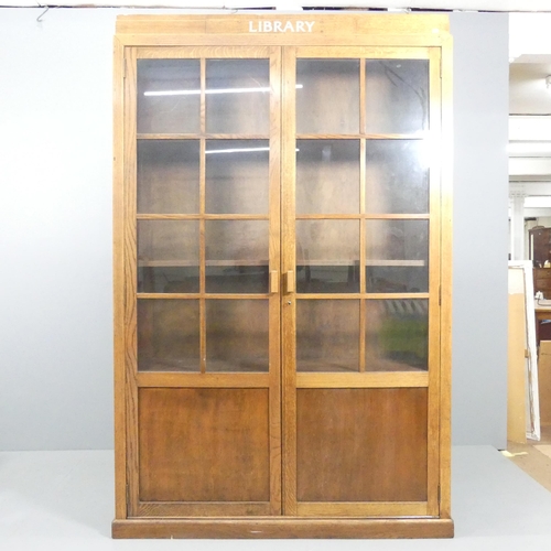 2006 - An early 20th century oak bookcase, with two lattice glazed doors revealing four shelves (two adjust... 