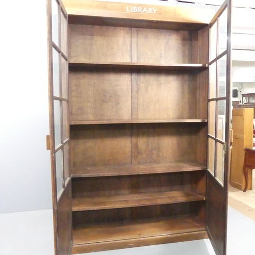 2006 - An early 20th century oak bookcase, with two lattice glazed doors revealing four shelves (two adjust... 