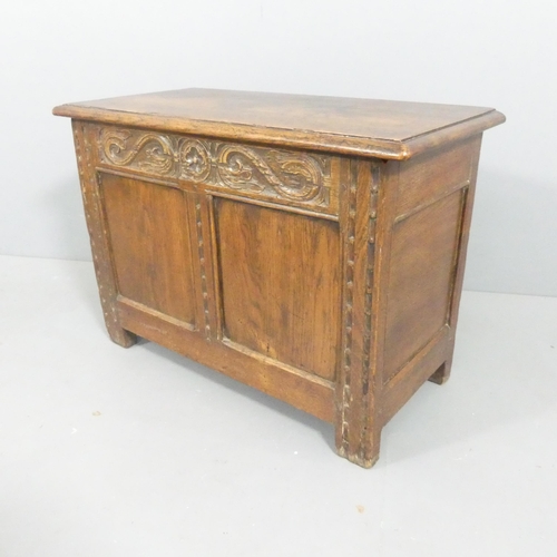 2105 - A French panelled oak blanket box, with carved decoration and raised on stile legs. 77x54x38cm.