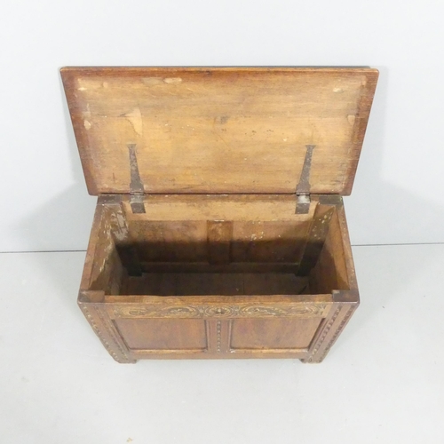 2105 - A French panelled oak blanket box, with carved decoration and raised on stile legs. 77x54x38cm.