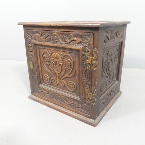 2108 - An antique oak Arts & Crafts style single door cabinet, with carved and panelled decoration. 43x41x3... 