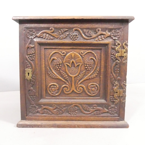 2108 - An antique oak Arts & Crafts style single door cabinet, with carved and panelled decoration. 43x41x3... 