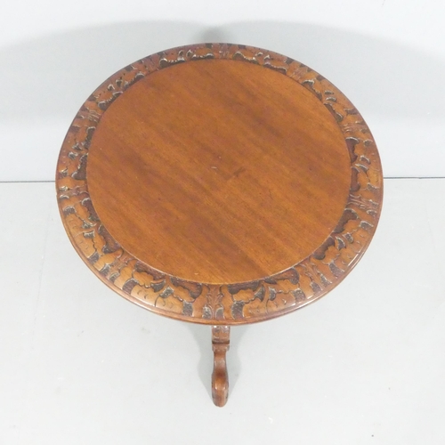 2113 - An antique mahogany circular topped occasional table, with carved decoration, turned central column ... 