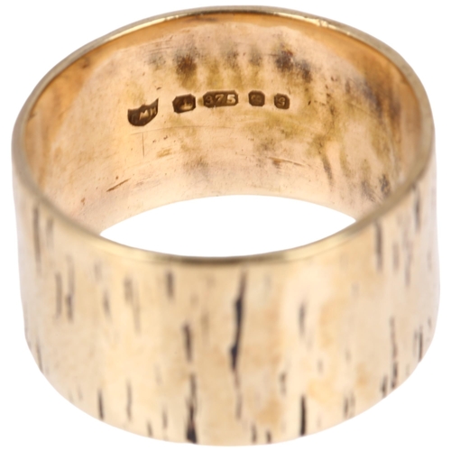 1166 - A late 20th century 9ct gold wedding band ring, maker PMH, London 1981, engraved naturalistic bark d... 