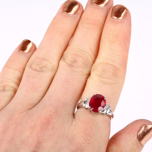 1189 - A modern 18ct white gold ruby and diamond dress ring, claw set with 2.7ct oval mixed-cut ruby flanke... 