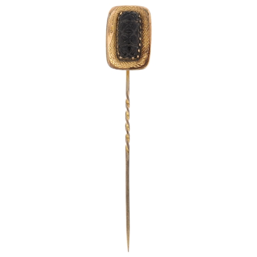 1206 - A Georgian jet stickpin, relief carved decoration, in unmarked yellow metal settings, head 19.8mm, o... 