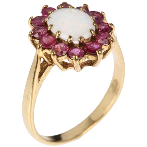 1313 - A late 20th century 9ct gold opal and ruby oval cluster ring, London 1978, claw set with oval caboch... 