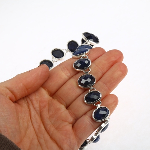 1394 - A long sterling silver graduated sapphire line necklace, rub-over set with oval rose-cut sapphires, ... 