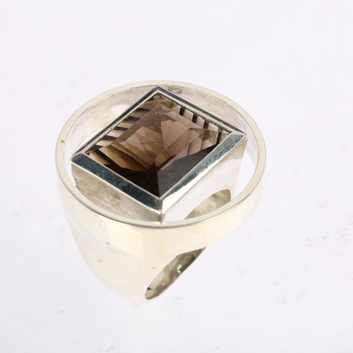 1465 - A modernist sterling silver laser-cut smoky quartz openwork ring, circular form with central rub-ove... 