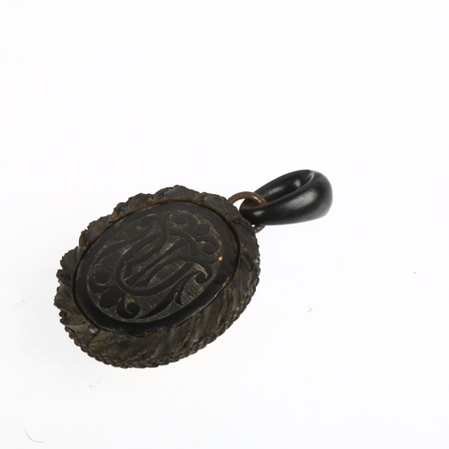 1550 - A 19th century carved jet mourning locket pendant, with monogram front and domed glass backing, 75.1... 